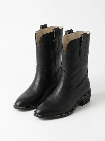 Un par de botas de estilo vaquero negras con superficie texturizada, puntera puntiaguda, tacón de bloque y costuras decorativas visibles.